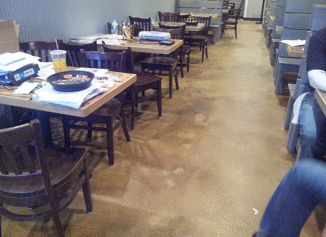 a restaurant with tables and chairs and a person sitting at a table