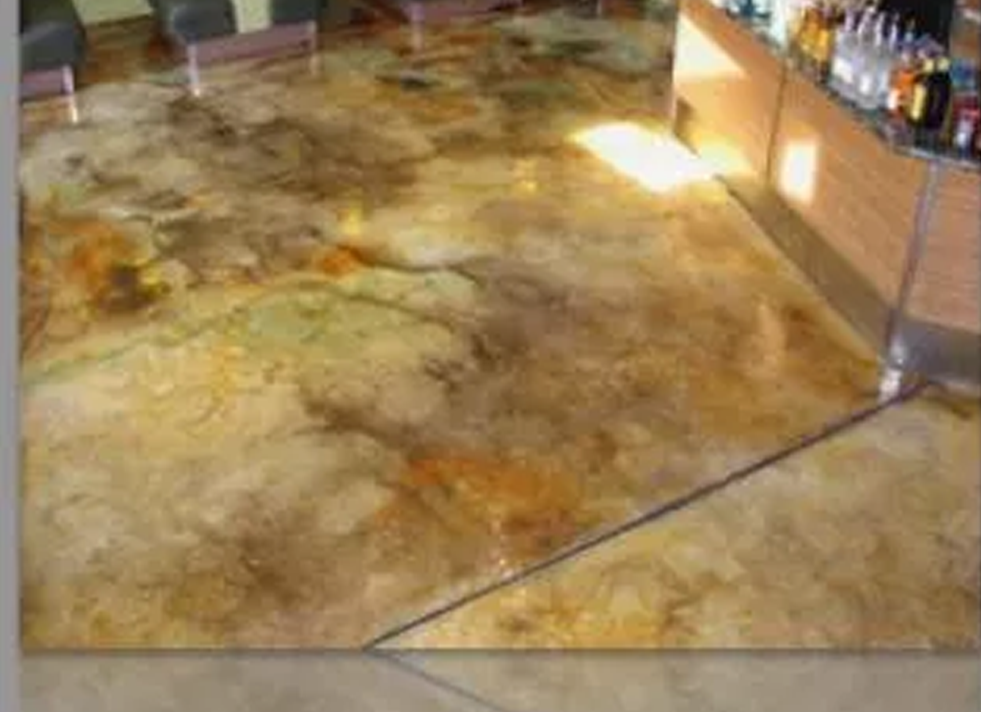 a concrete floor in a room with a bar in the background .