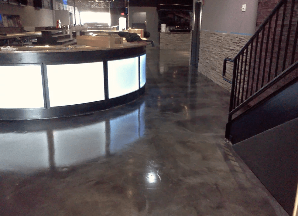 a large room with a bar and stairs in it