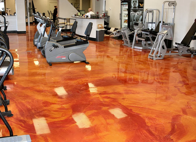 a gym with a red floor and a lot of exercise equipment