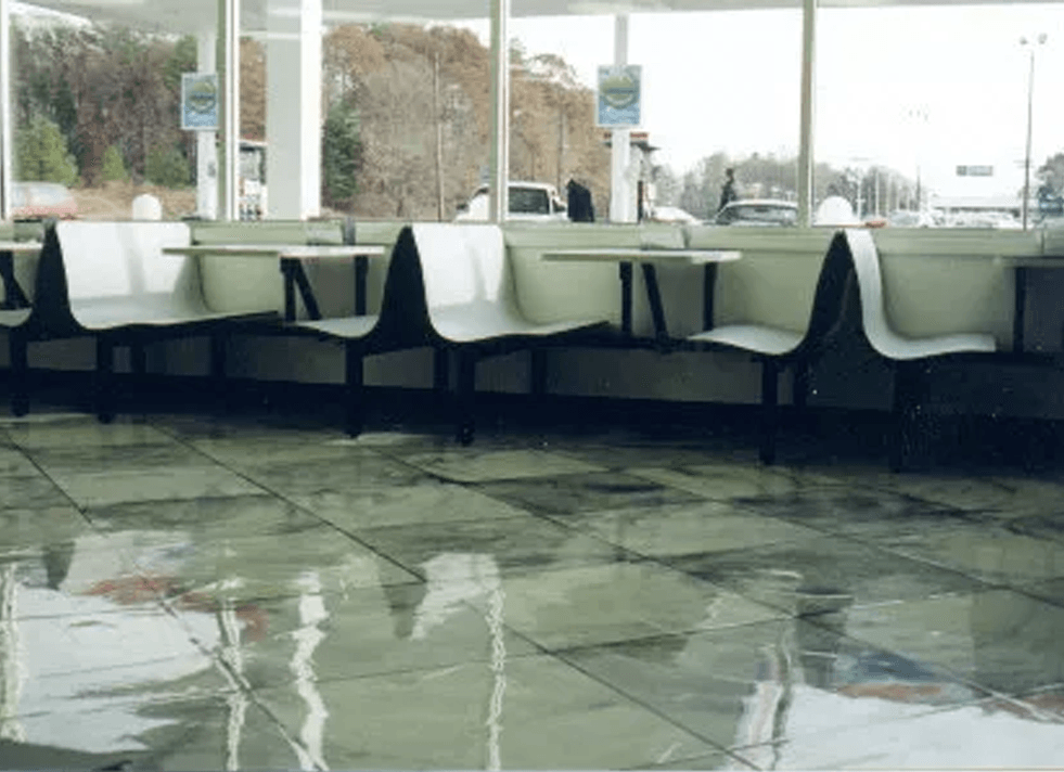 a row of chairs and tables in a restaurant .