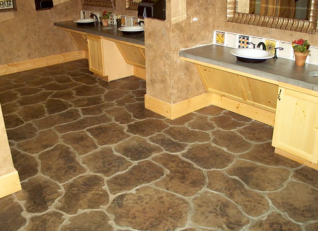 a bathroom with a stone floor and sinks