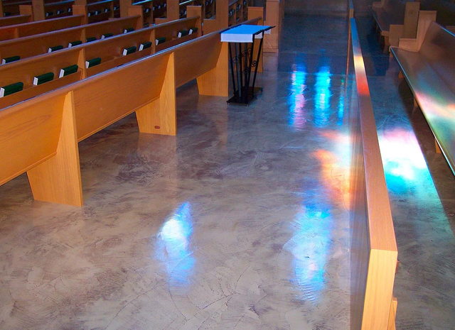 a church with rows of wooden benches and a podium