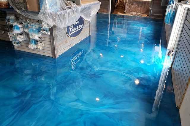 a blue metallic floor in a store with a counter in the background .