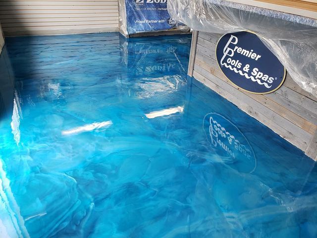 a blue metallic floor with a sign that says premier pools & spas