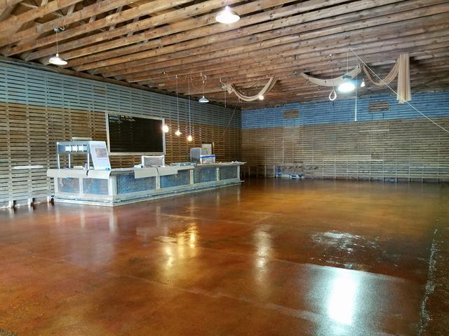 a large empty room with a wooden ceiling and a concrete floor .