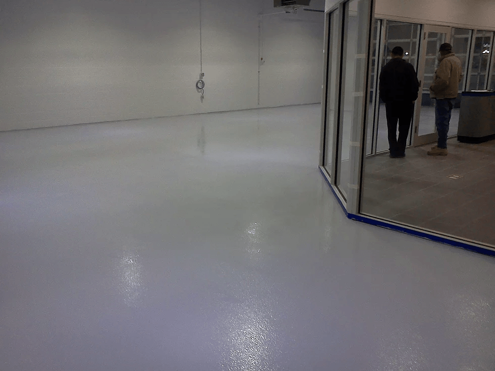 two men are standing in a room with a white floor .