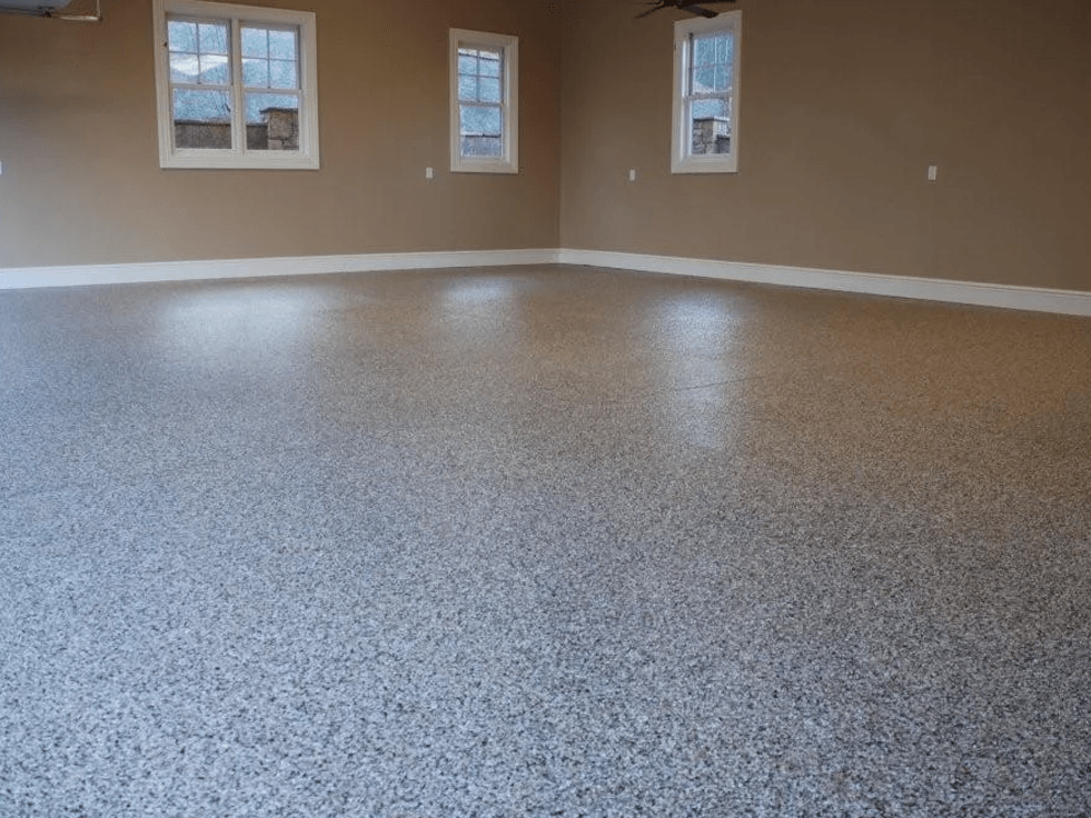 an empty room with a gray floor and two windows