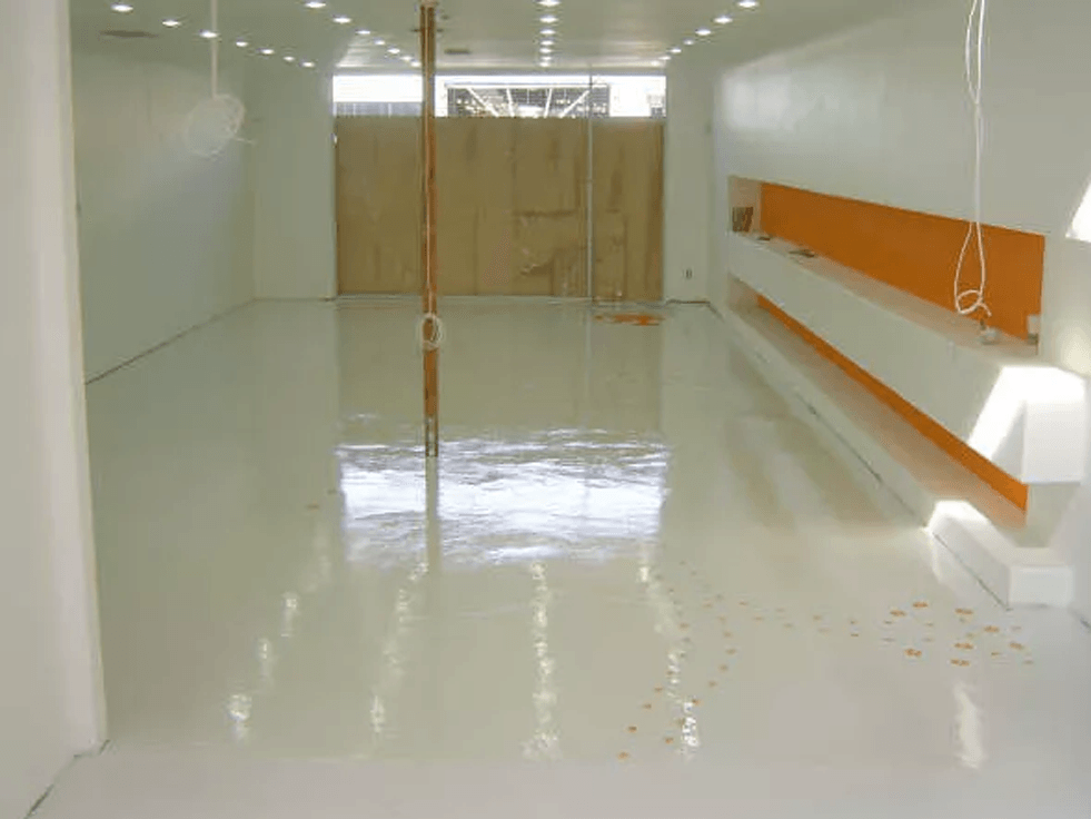 an empty room with a white floor and orange walls