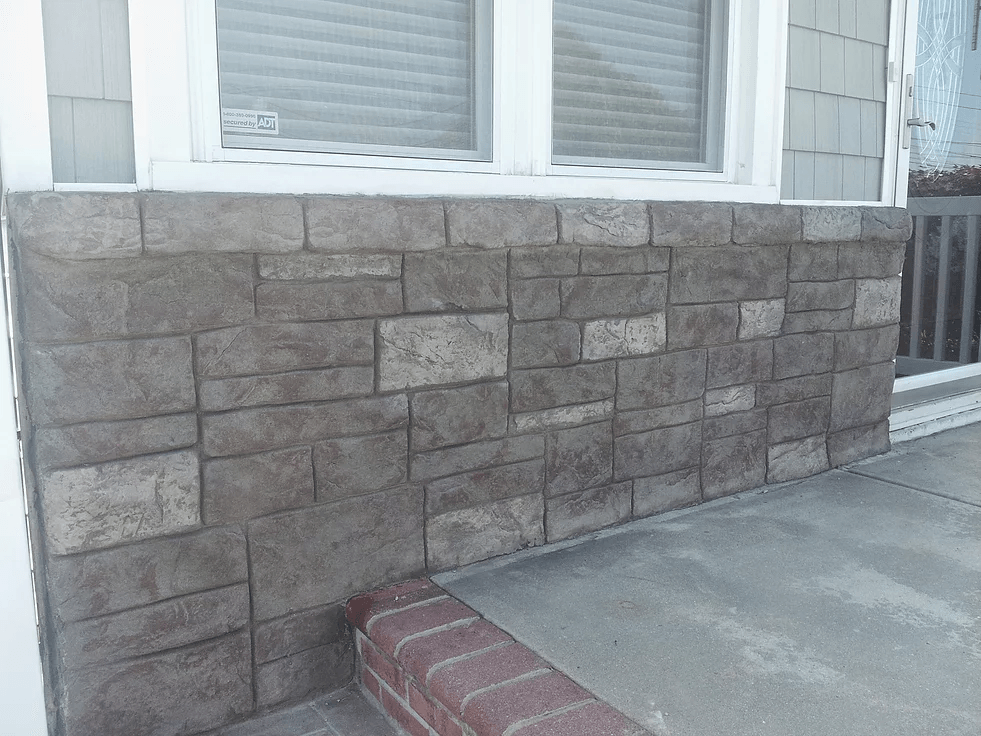 a brick wall next to a window on the side of a house .