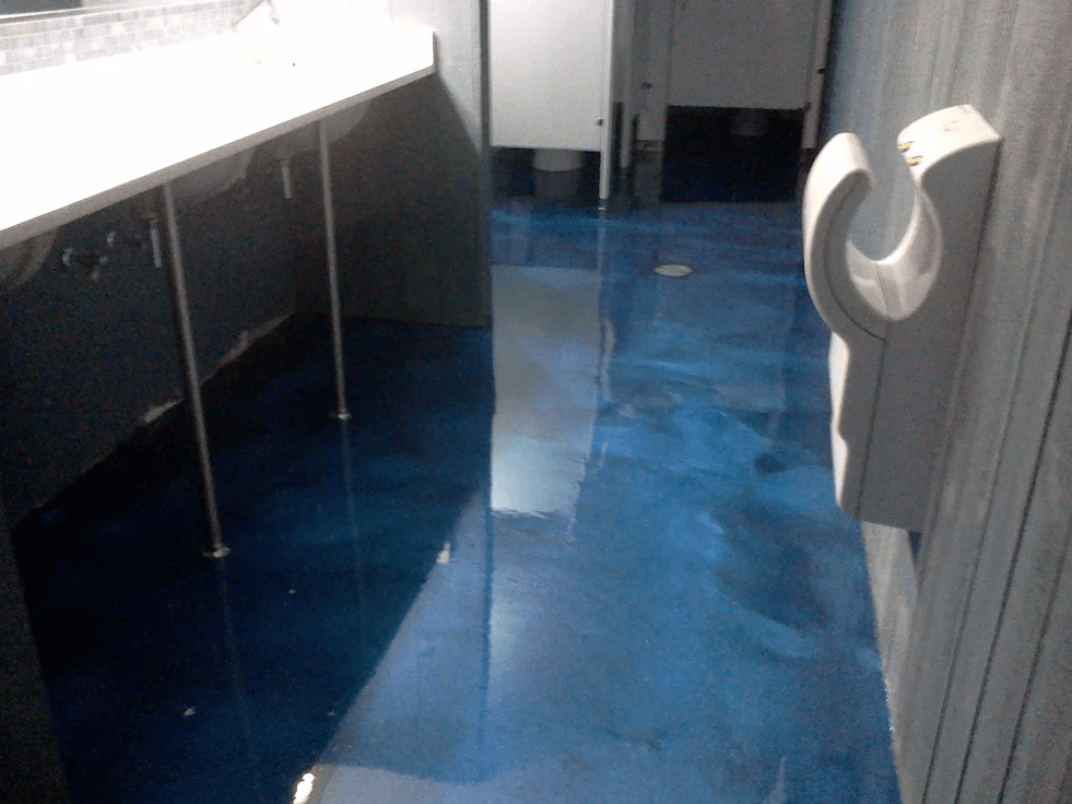 a bathroom with a blue floor and a hand dryer