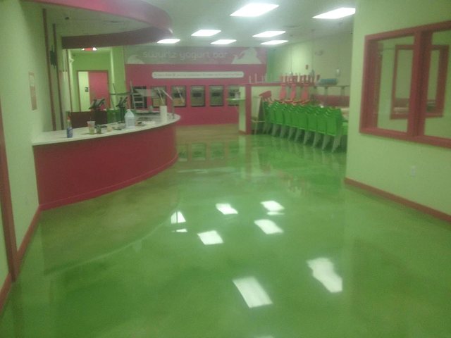 a large room with a green floor and a red counter .