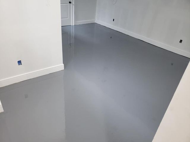 a room with a gray floor and white walls .