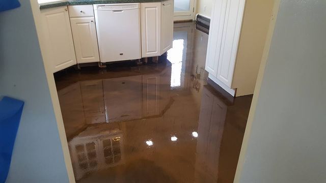 a kitchen with a flooded floor and white cabinets .