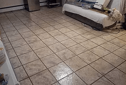 a living room with a tiled floor and a couch .