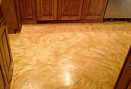 a kitchen with a concrete floor and wooden cabinets .