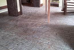 a brick floor in a room with a table and chairs .