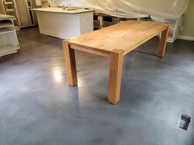 a wooden table is sitting on a concrete floor in a room .