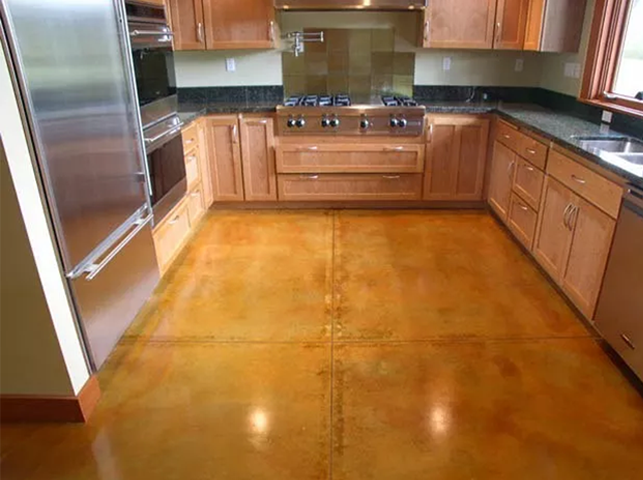 a kitchen with wooden cabinets , stainless steel appliances and a concrete floor .