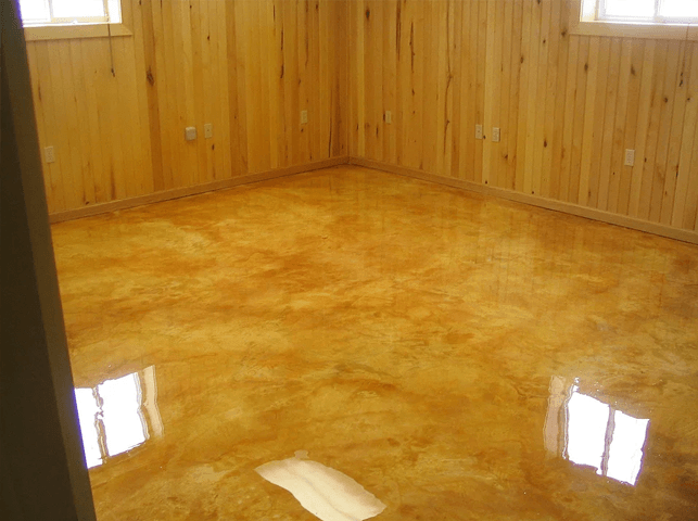 a room with a shiny concrete floor and wooden walls .