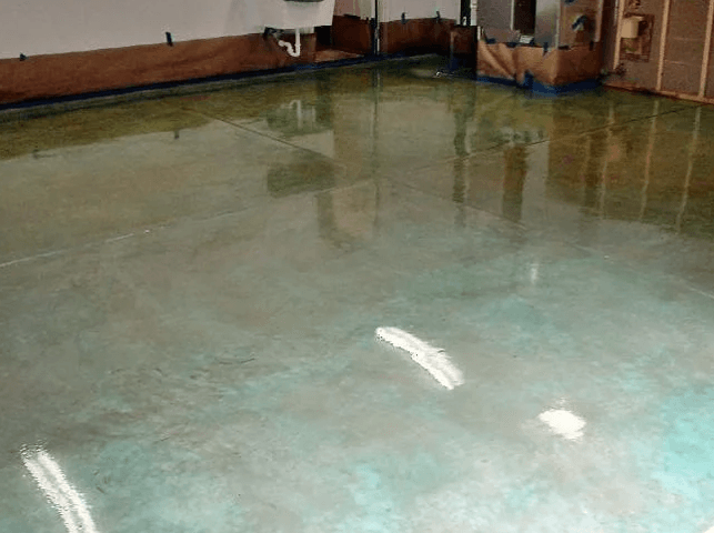 a shiny concrete floor in a room with a sink