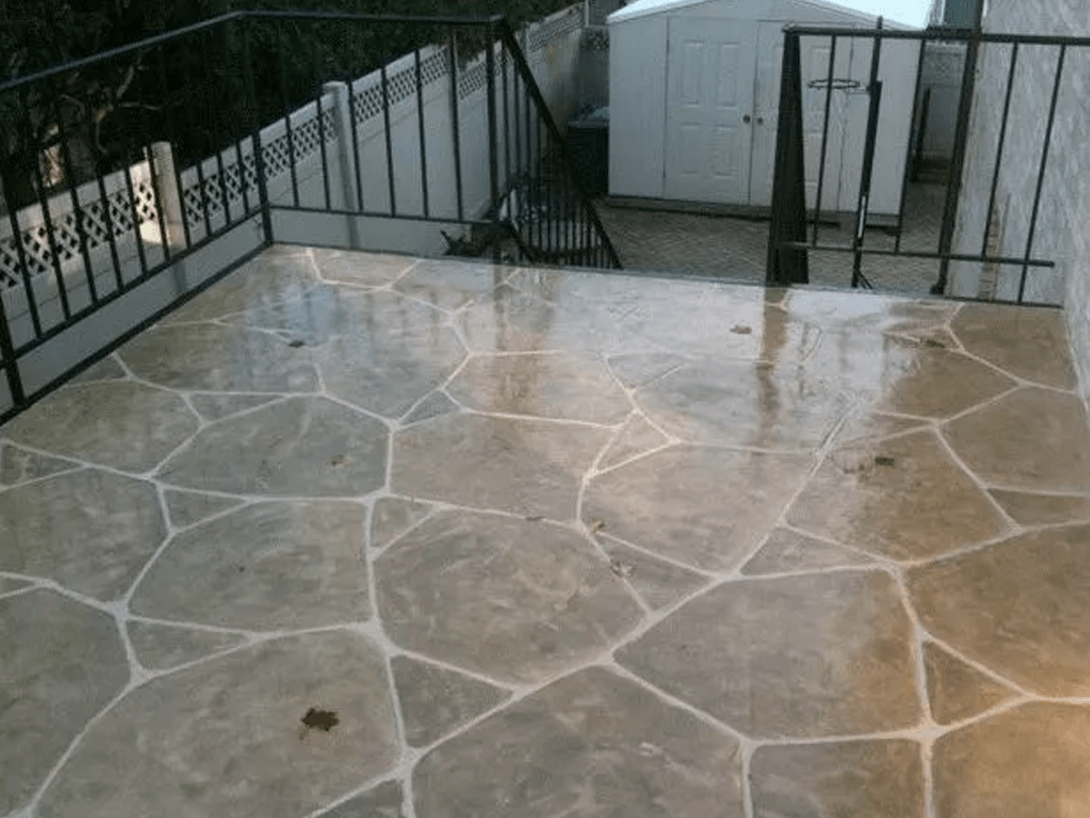 a patio with a shed and stairs in the background