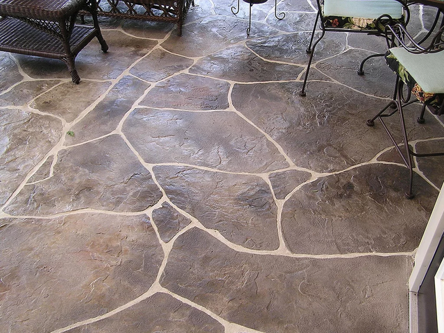 a stone floor with a table and chairs on it