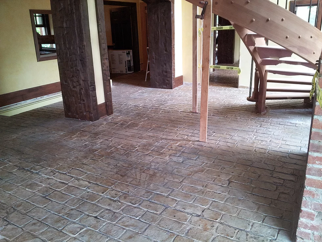 a room with a spiral staircase and a brick floor