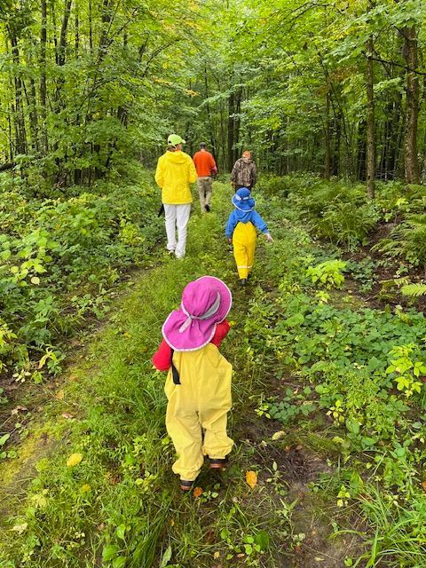 a family in yellow walking in the woods