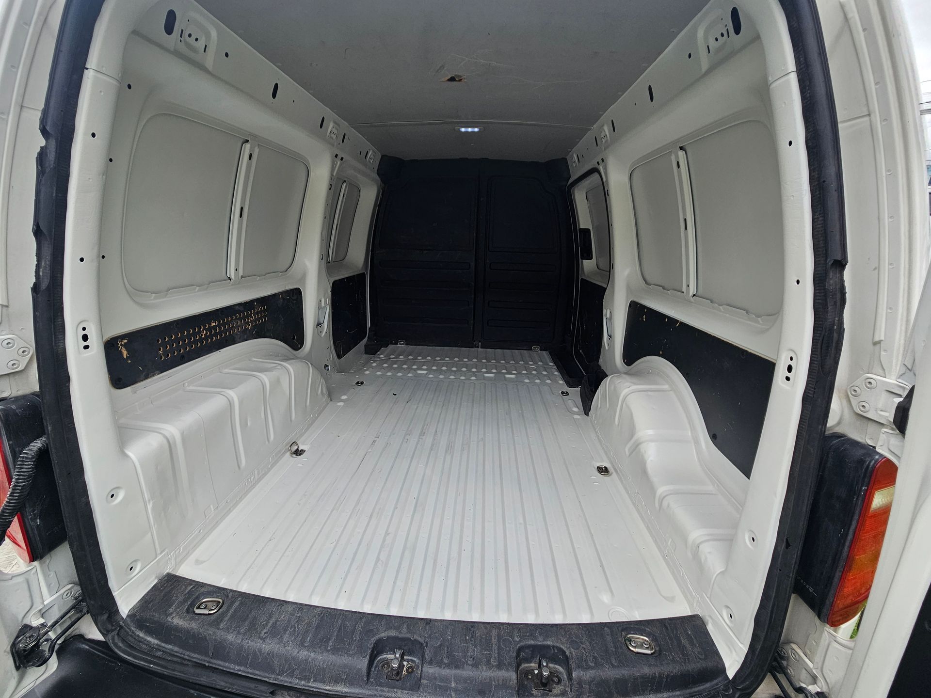 Interior de furgoneta de carga blanca vacía, incluidos suelo y paneles laterales.