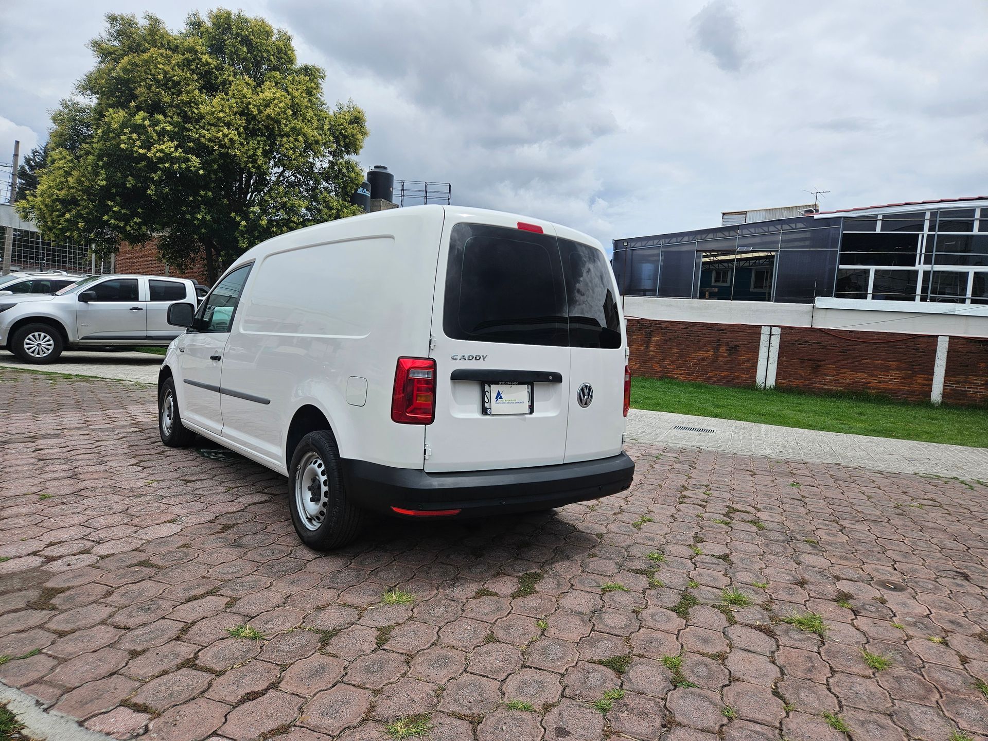 Furgoneta de carga blanca estacionada sobre adoquines.