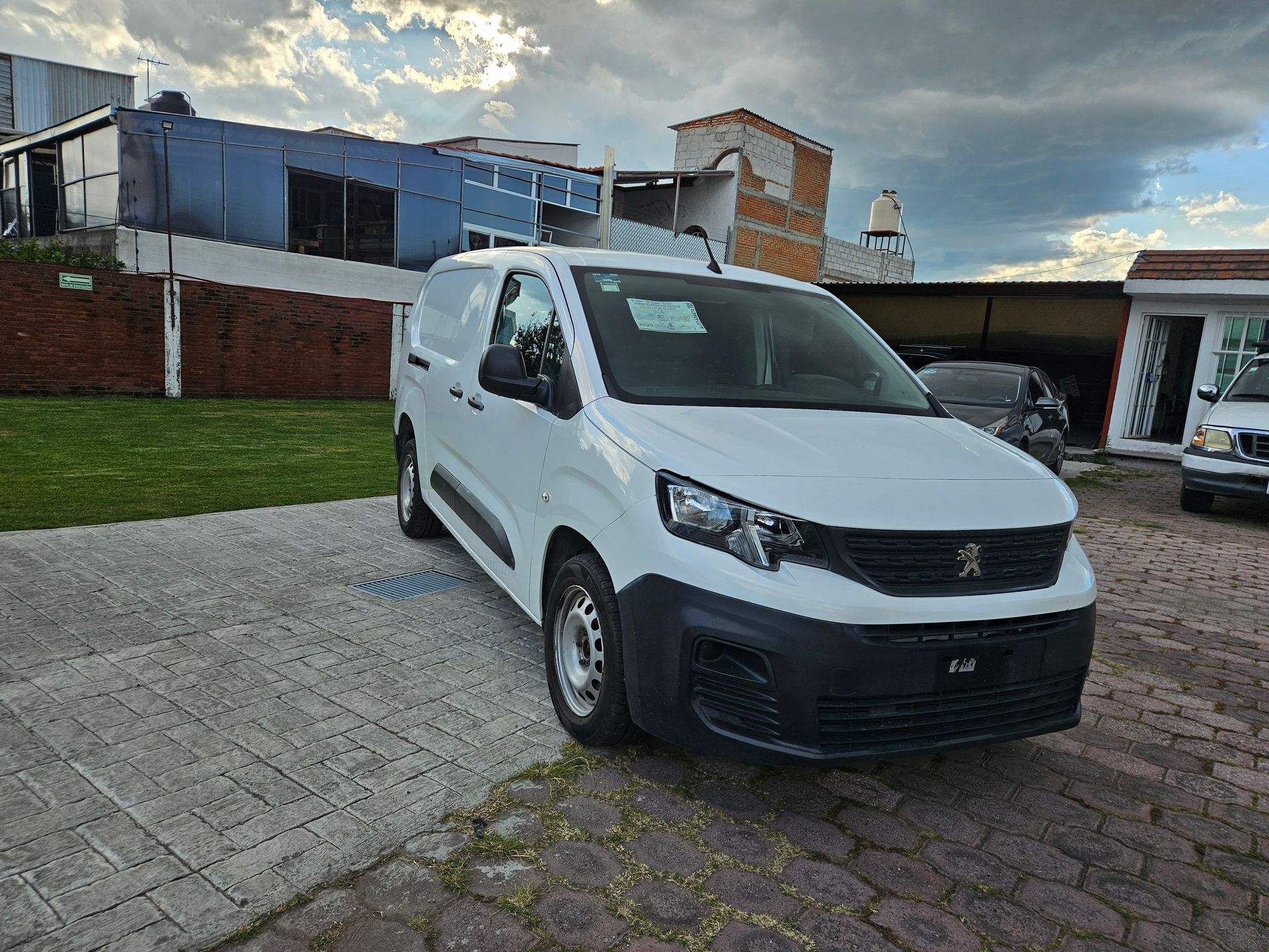 Furgoneta Peugeot Partner de color blanco aparcada al aire libre.