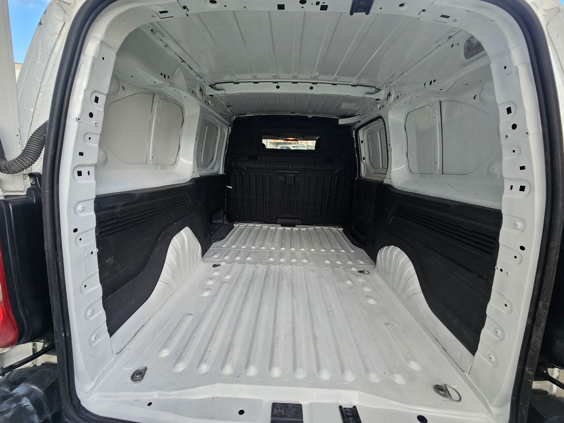 Interior de camioneta de carga blanca vacía con paneles laterales y aberturas de ventanas de color negro.