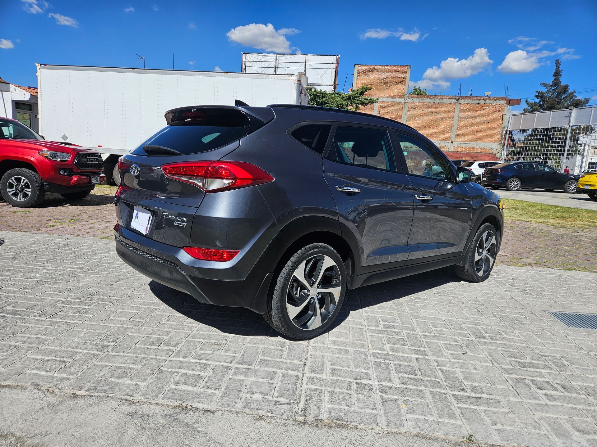 SUV Hyundai Tucson gris estacionado al aire libre en un día soleado.