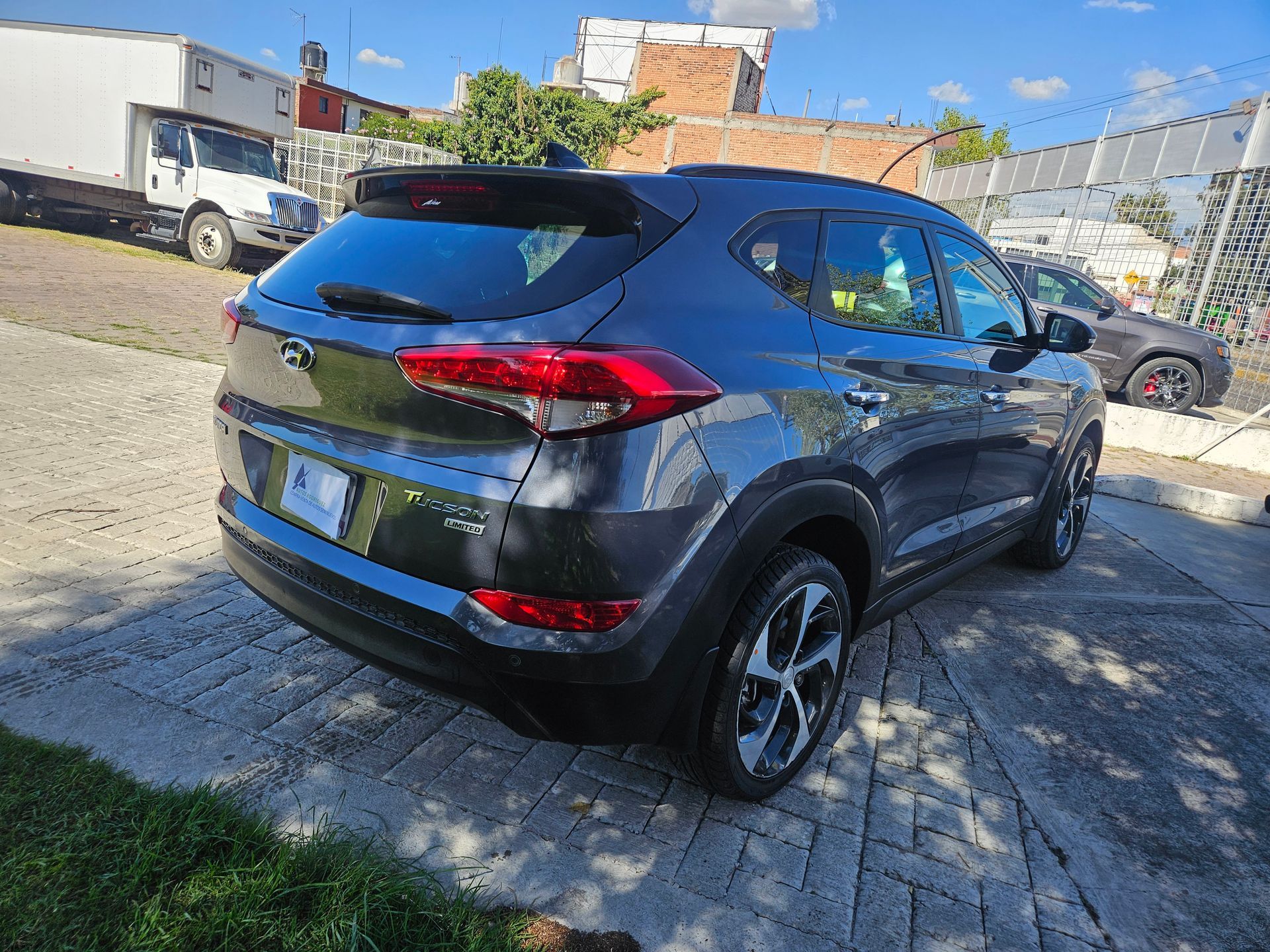 SUV Hyundai Tucson gris estacionado al aire libre en un día soleado.