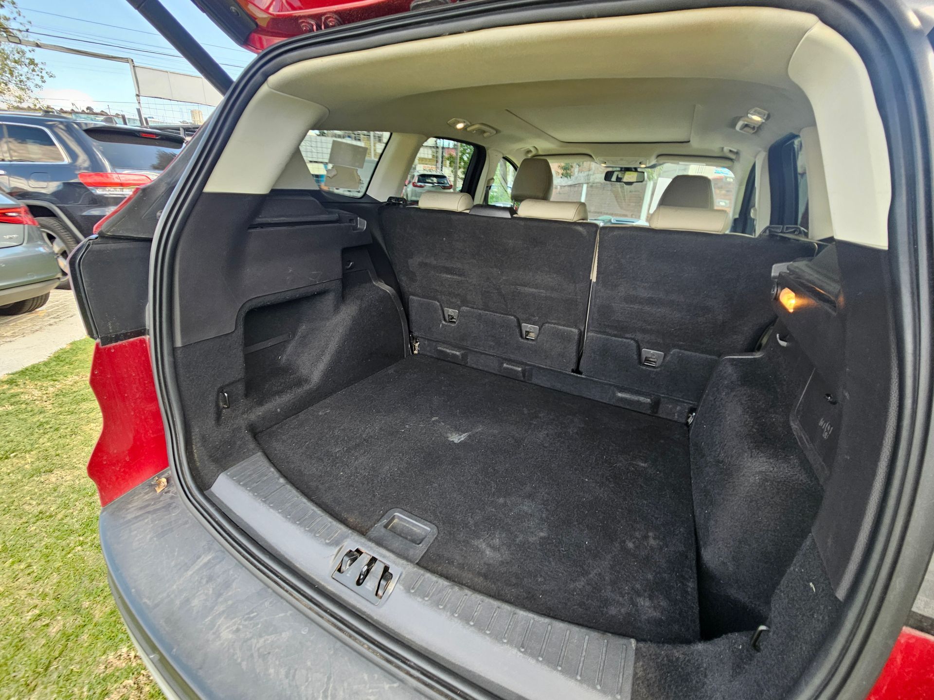 Parte trasera abierta de una SUV Ford roja que muestra el espacio de carga vacío y los asientos traseros plegados.