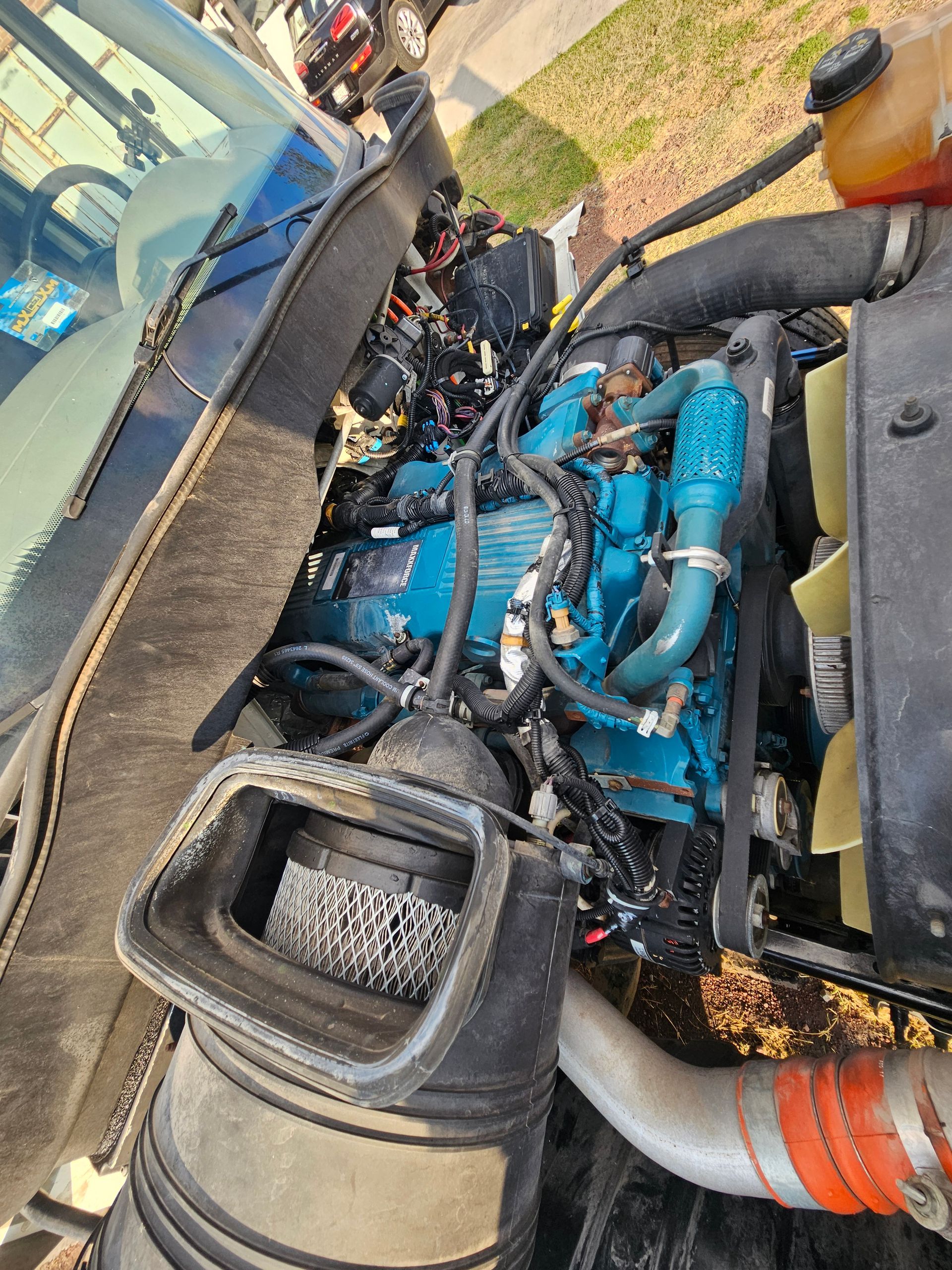 Compartimiento del motor de un camión International azul, que muestra los componentes del motor.