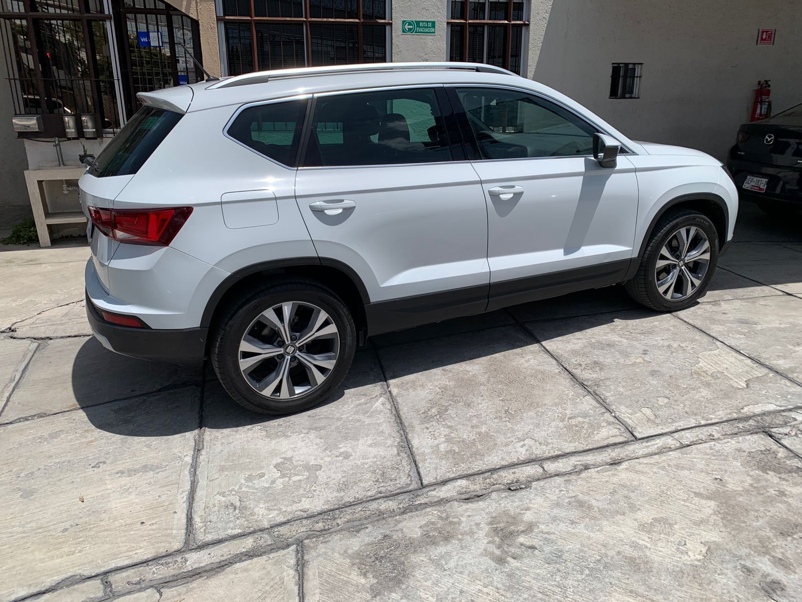 SUV SEAT Ateca de color blanco aparcado sobre baldosas de hormigón.
