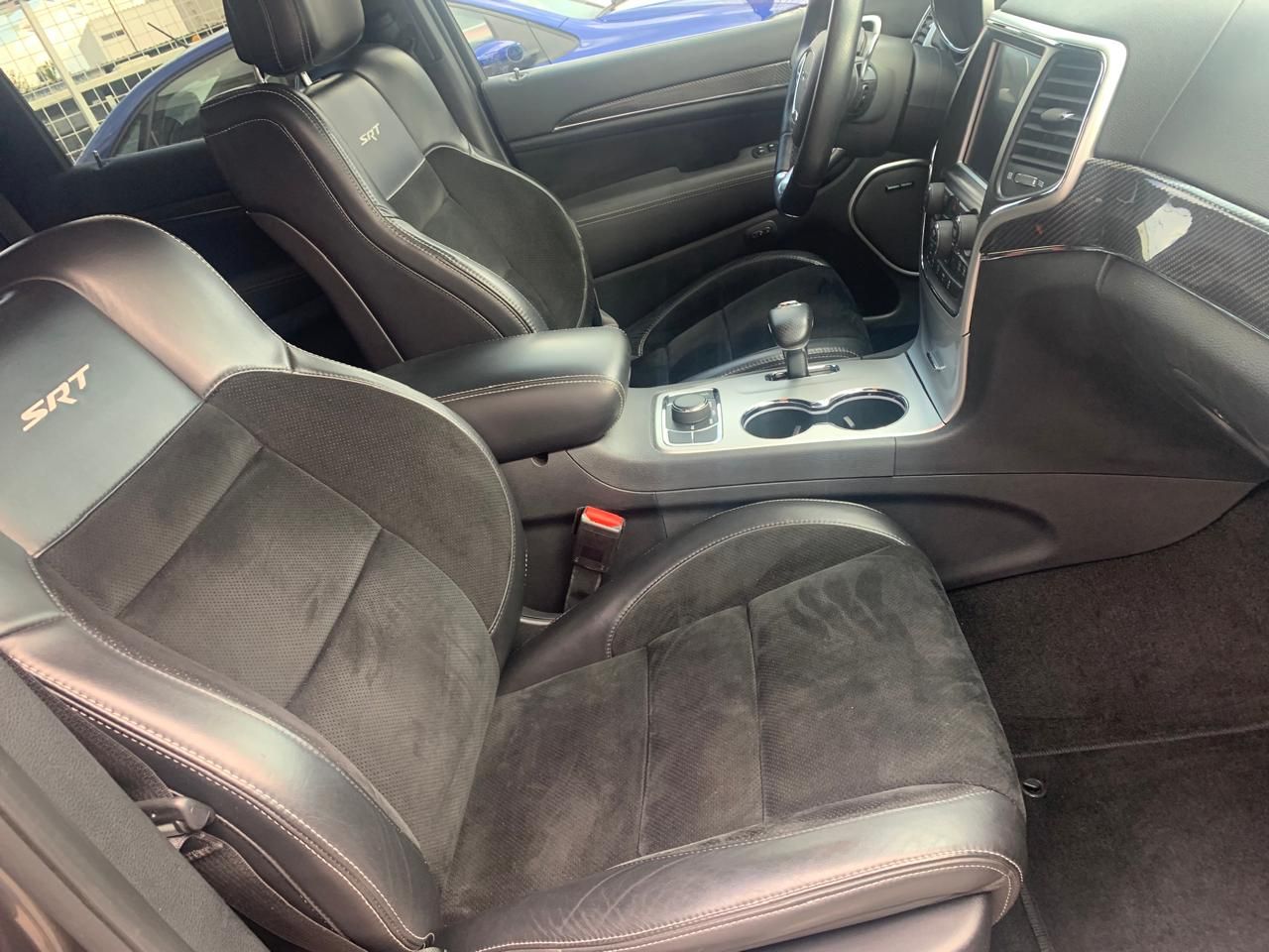 Interior de cuero negro de un automóvil, incluyendo asientos, tablero y consola central. Logotipo 