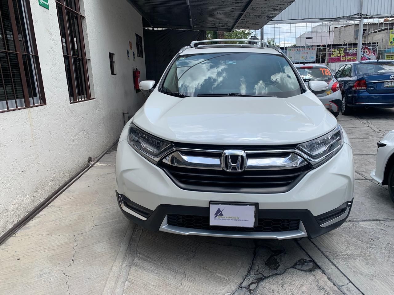 SUV Honda CRV blanco estacionado frente a un edificio.