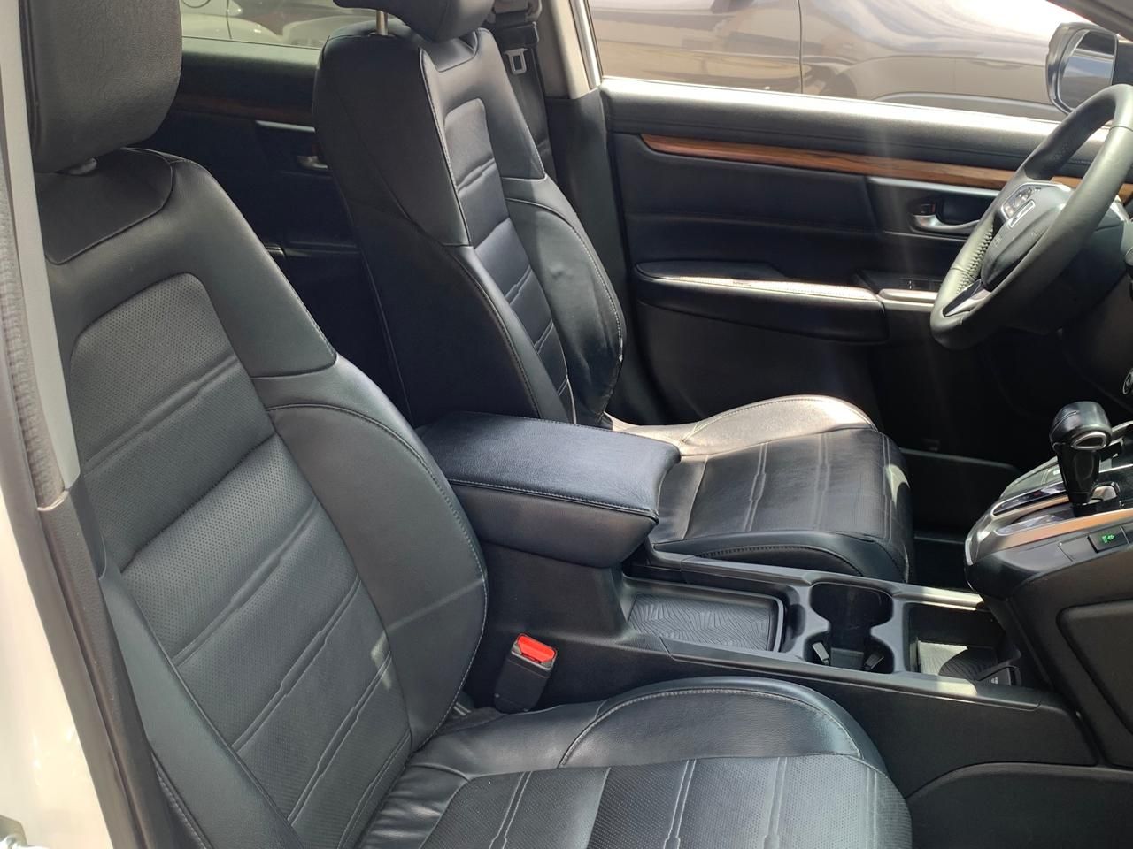 Interior de coche de cuero negro con asientos, consola y volante.