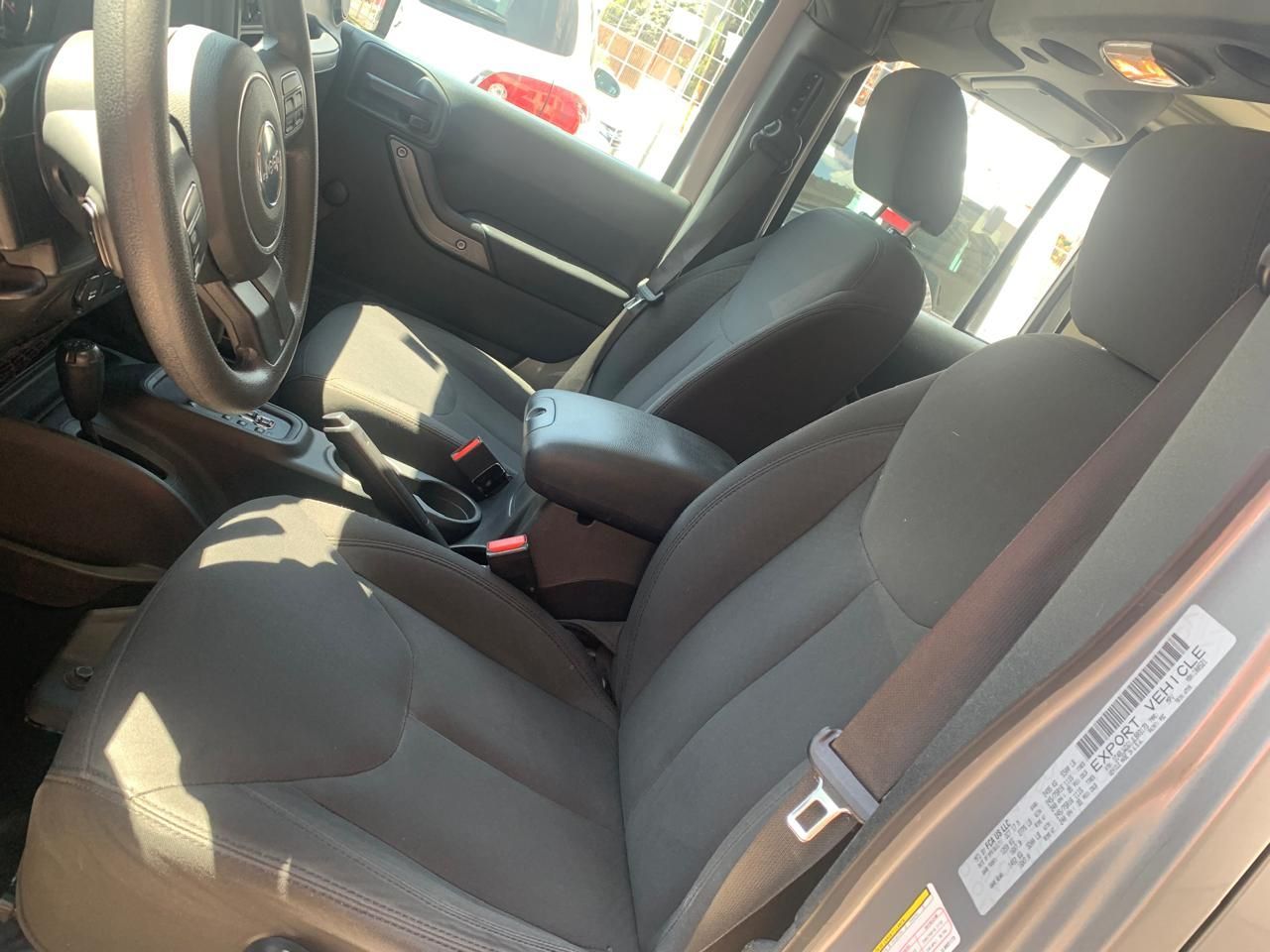 Vista interior de un Jeep gris. Se ven los asientos delanteros, el volante y la consola.