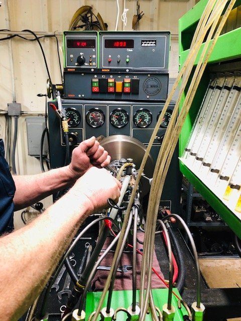 Worker Testing Fuel Pump on a Machine