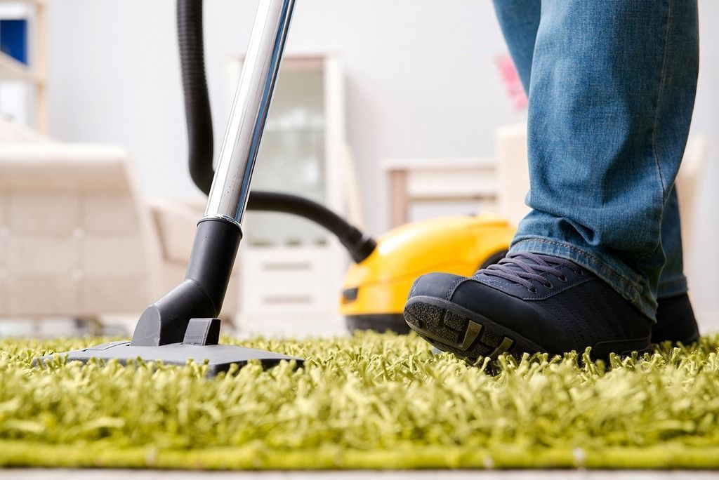 Cleaner Cleaning Yellow Carpet With Vacuum Cleaner