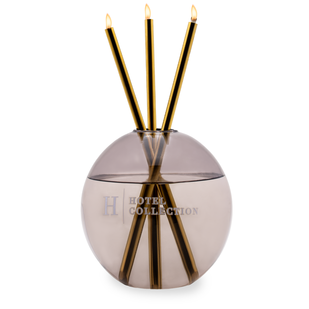 A hotel collection reed diffuser with three candles in it