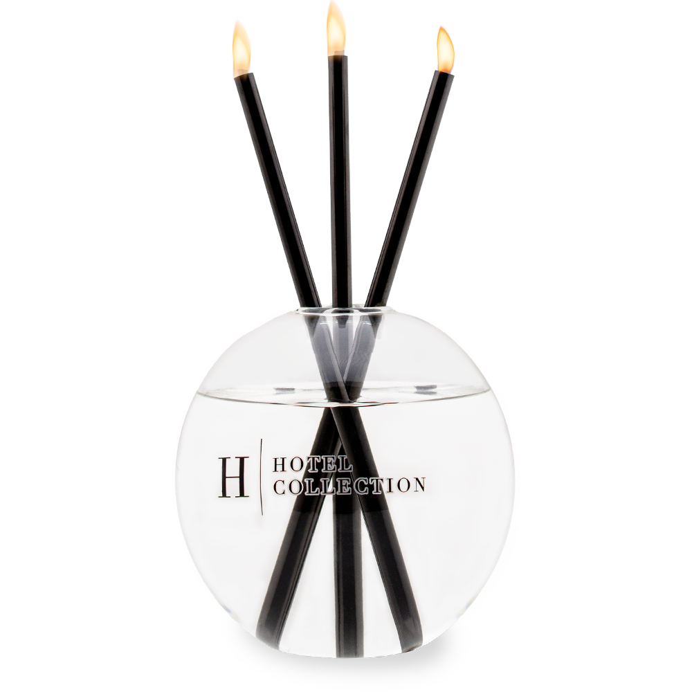 A glass candle holder with three candles in it