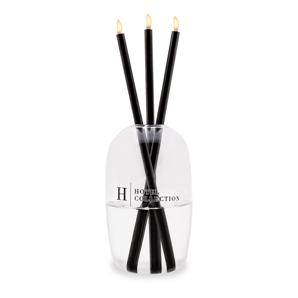 A reed diffuser with three candles inside of it.