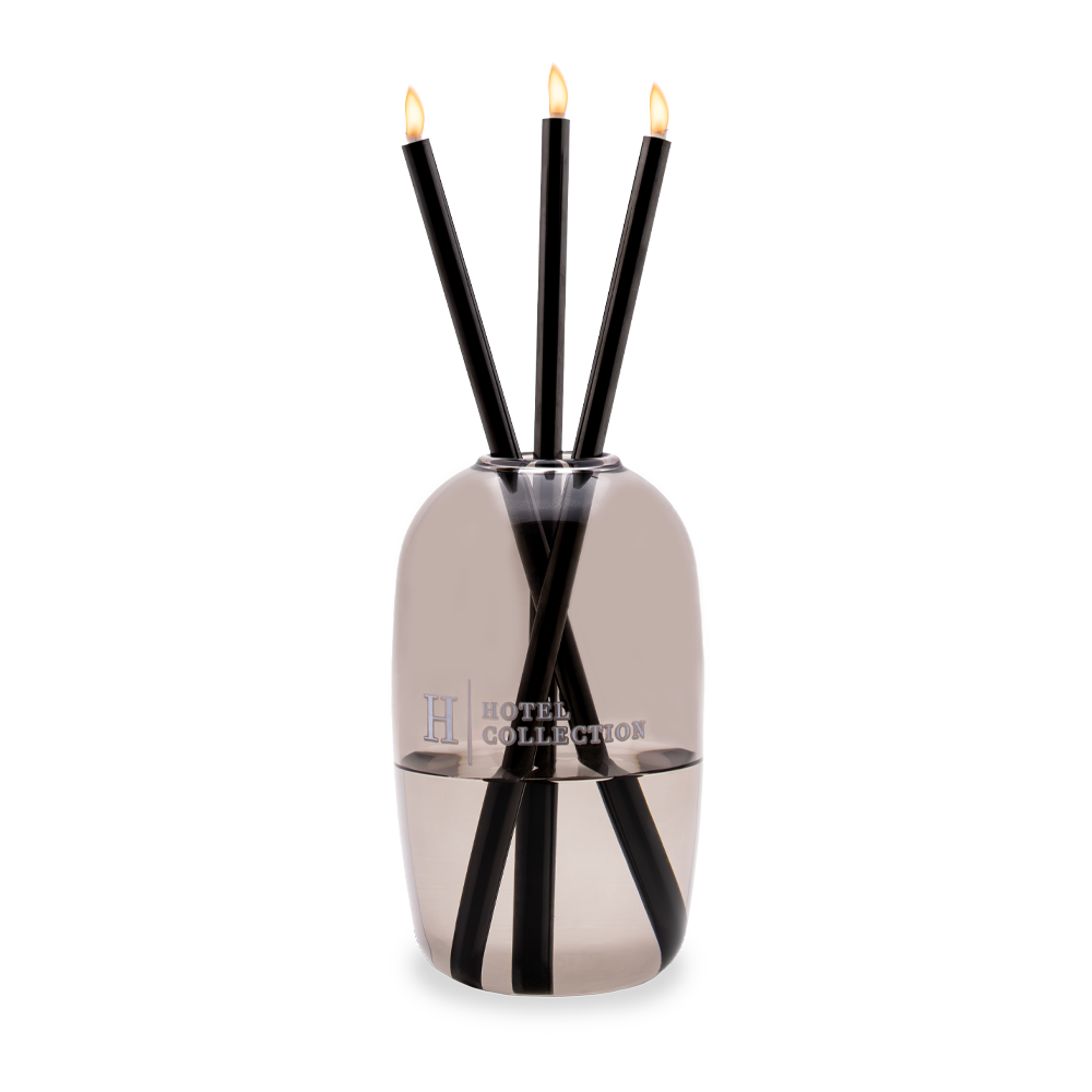 A hotel collection reed diffuser with three candles in it