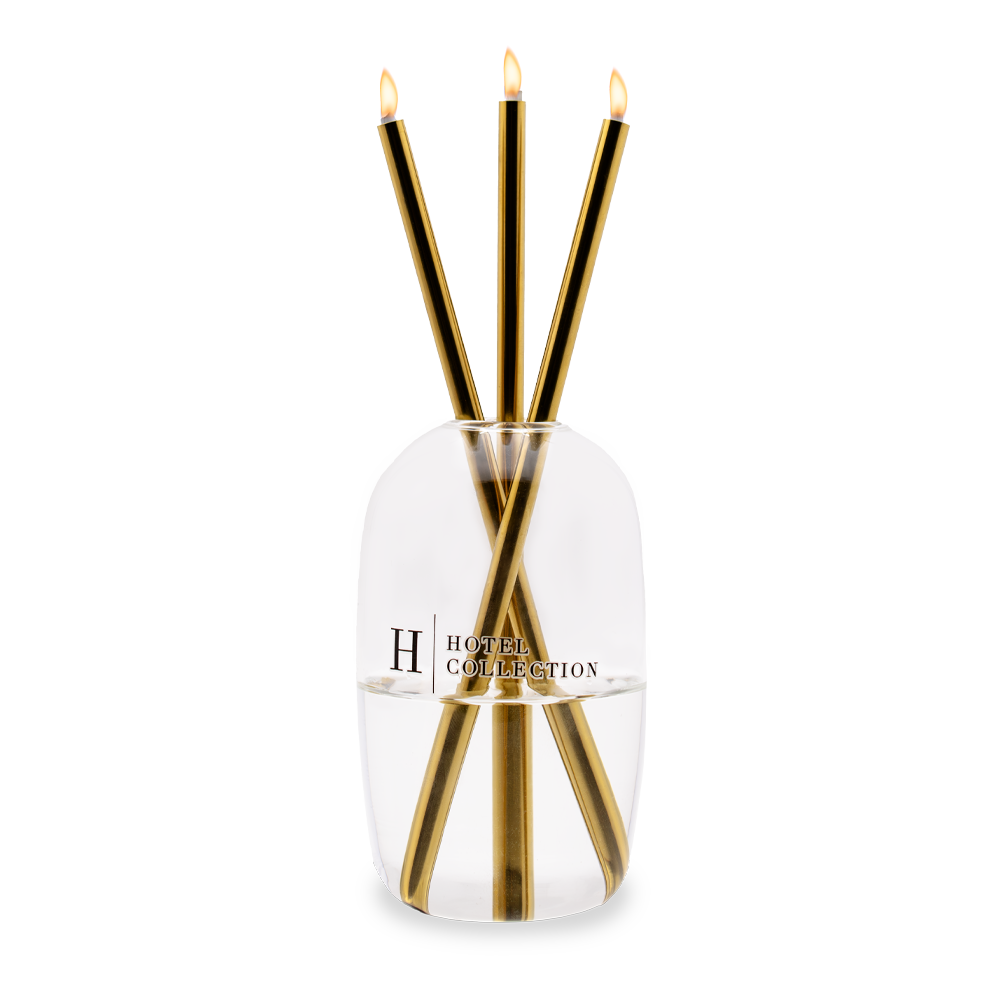 A candle in a glass container with the letter h on it