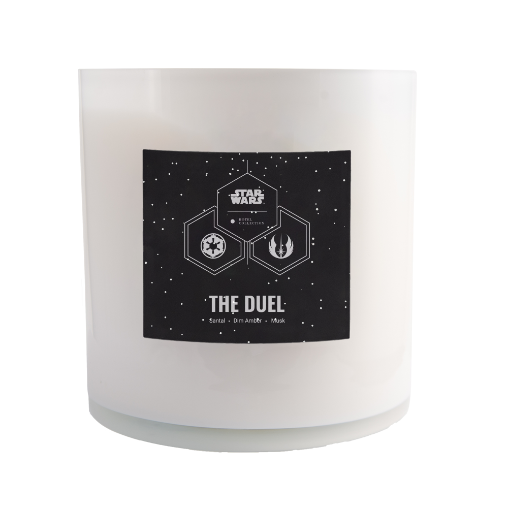 A white candle with a black label that says the duel